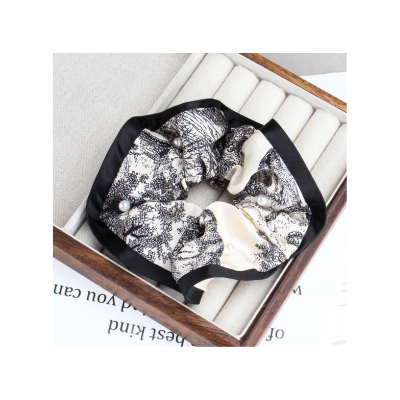 Patterned satin scrunchie, fashionable women's hair tie, hair accessory for tying ponytails.
