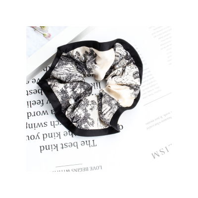 Patterned satin scrunchie, fashionable women's hair tie, hair accessory for tying ponytails.