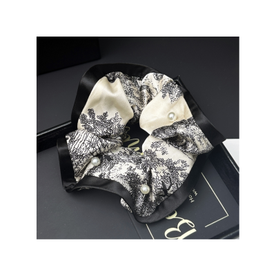 Patterned satin scrunchie, fashionable women's hair tie, hair accessory for tying ponytails.