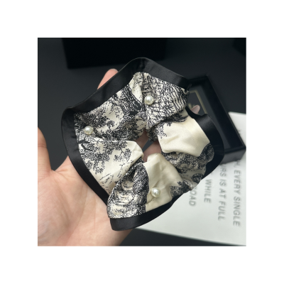 Patterned satin scrunchie, fashionable women's hair tie, hair accessory for tying ponytails.